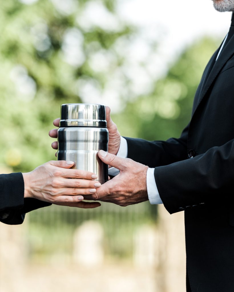 cropped view of senior man and woman holding mortuary urn cropped view of senior man and woman holding mortuary urn